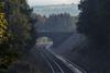 Empty rail track passing beneath a bridge in the English countryside.