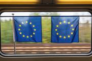 Two European flags hanging in a train window