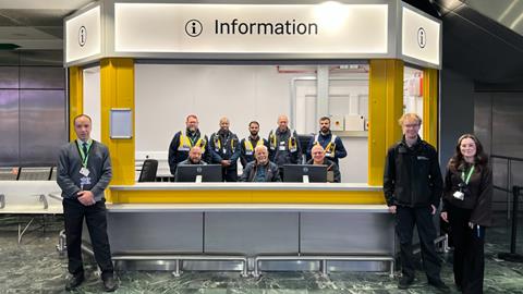 London Euston customer information hub with staff providing passenger support at station concourse